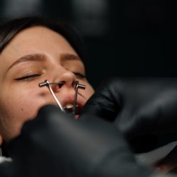 Piercing studio. a master pierces a girl's nose